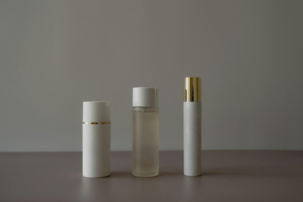 Simple minimalist arrangement of cosmetic bottles on a gray background.