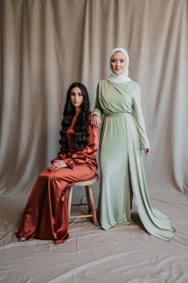 a woman sitting next to a woman in a green dress