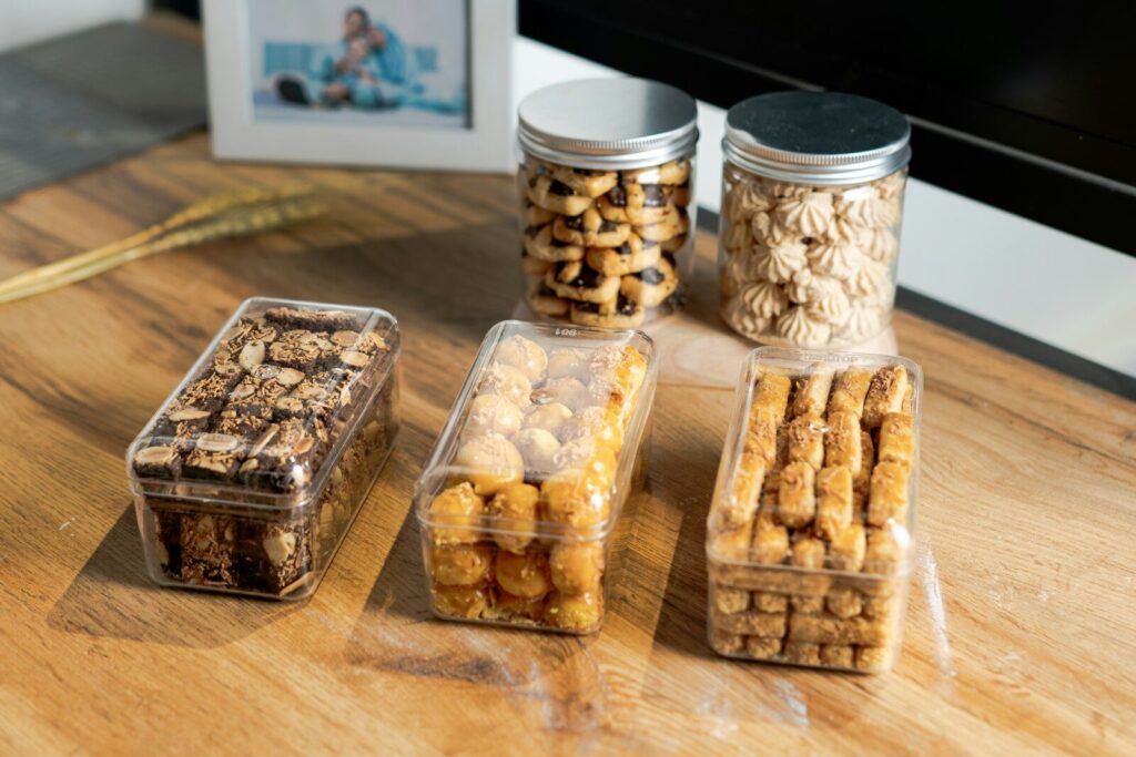 Assortment of cookies in clear plastic containers on table.
