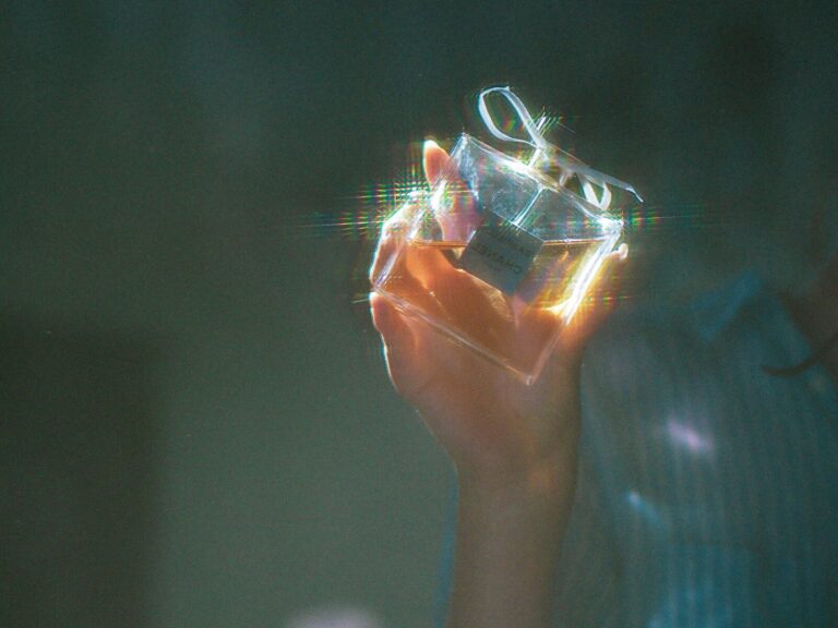 person holding clear glass container