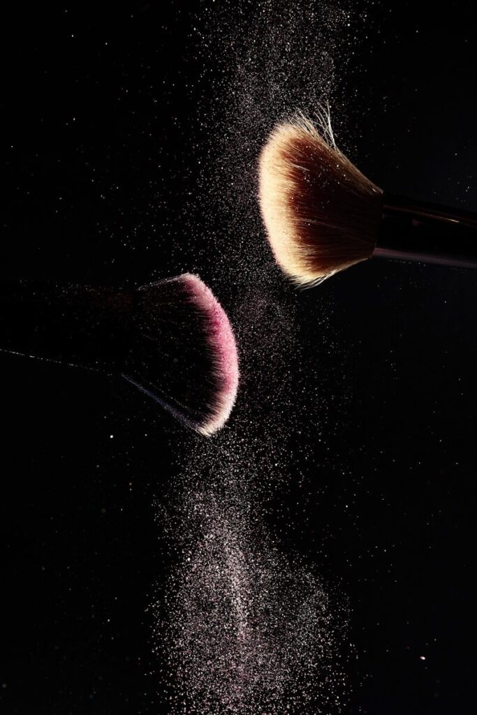 a close up of two makeup brushes on a black background