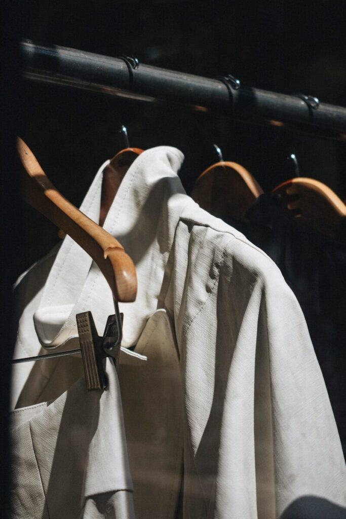 white dress shirt hanged on brown wooden clothes hanger