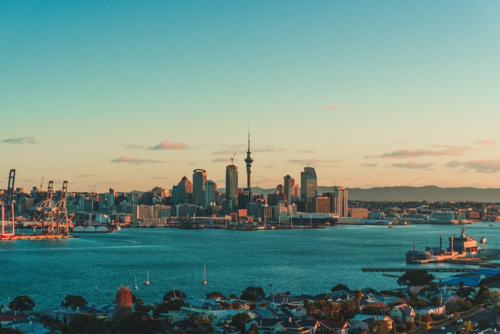 The Auckland skyline and harbor under a warm low sun in New Zealand