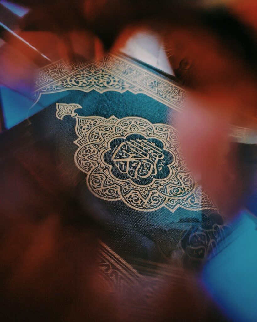 A dark green book with intricate gold calligraphy and patterns on the cover
