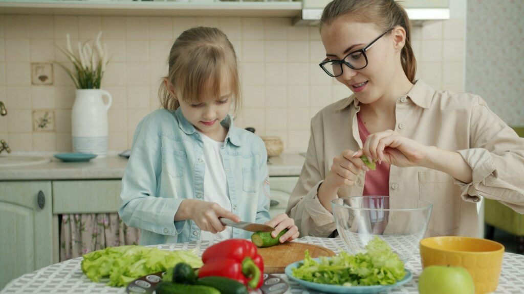 Mother and daughter preparing salad in the kitchen